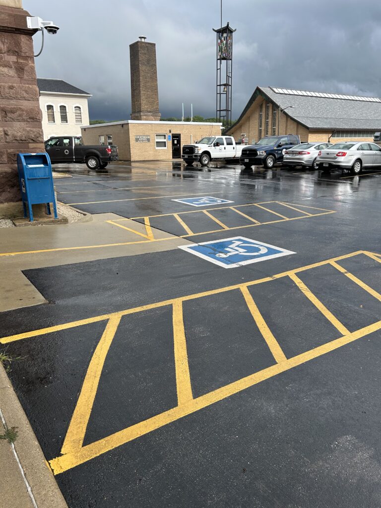 rainy parking lot with bright painted lines for accessible parking
